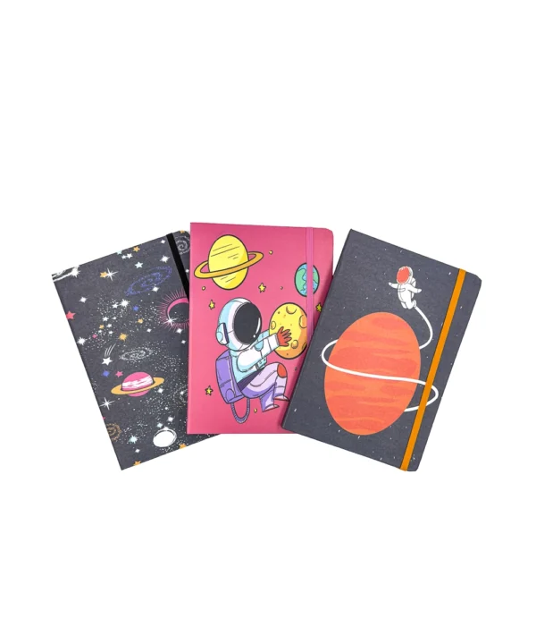 Tres cuadernos-agenda cuadriculados exhibiendo sus vibrantes carátulas con diseños de planetas y astronautas, cada uno con su práctico cierre de caucho.