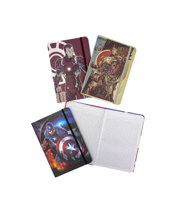 Cuatro cuadernos-agenda héroes apilados, con uno abierto revelando sus páginas cuadriculadas perfectas para planificación, y el cierre de caucho.